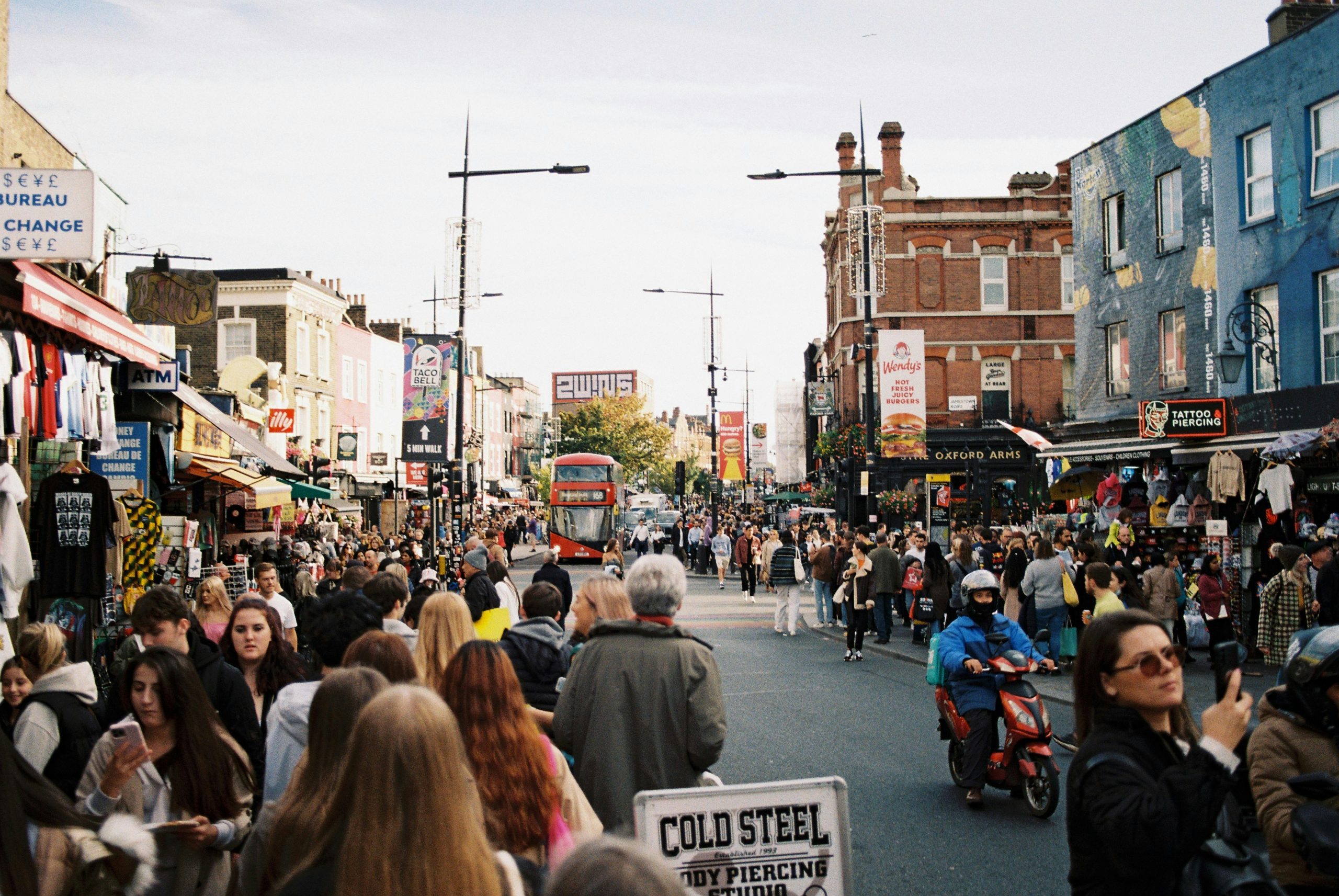 A busy city street filled with people, shops, and traffic